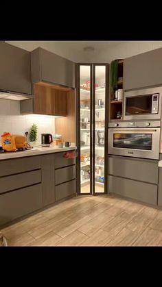 a kitchen with wooden floors and stainless steel appliances