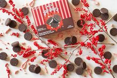 an oreo cookie box surrounded by red berries and sprinkles on a white surface