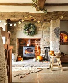 a living room filled with furniture and a fire place next to a fireplace covered in pumpkins