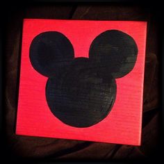 a mickey mouse face painted on a red canvas