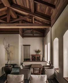 a living room filled with lots of furniture and wooden beams on the ceiling above it