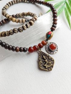 This unisex gemstone necklace features: ~ Bronze Phra Khun Phaen Amulet Pendant ~ Silver plated Carnelian Pendant  ~ Vintage Carnelian Beads ~ Black hematite beads  ~ Inlaid Tibetan brass turquoise and coral bead ~ Carved Brown and Smooth Brown Bone Beads ~ Raw brass lobster claw + Ring (with a vintage carnelian at clasp) * It is 20 inches long and perfect for layering with other JBO necklaces.  Thanks for shopping with JewelryByOri! Spiritual Carnelian 8mm Bead Jewelry, Spiritual Carnelian Beads Jewelry 8mm, Spiritual Carnelian 8mm Beaded Jewelry, Spiritual Carnelian Jewelry With 8mm Beads, Handmade Vintage Beaded Necklaces For Meditation, Spiritual Carnelian Jewelry For Festivals, Vintage Gemstone Beads Jewelry For Meditation, Spiritual Festival Agate Beaded Necklaces, Spiritual Agate Beaded Necklaces For Festival