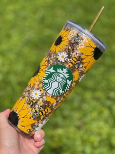 the starbucks cup is decorated with sunflowers and glittery gold flecks