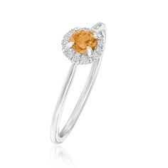 a ring with an orange and white diamond in the shape of a heart on it