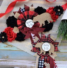 two wreaths with red and black flowers are on the side of a wooden table