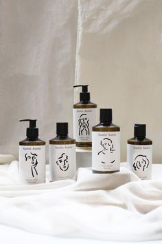 five different types of hand soaps on a white blanket