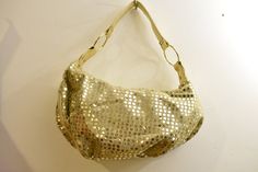 "A large glittery gold puffy fabric sequined casual evening or special event bag with a gold toned leatherette strap and trim. Casual - sparkly lots of bling!  * ochre twill lining * zippered wall pocket.  * 18\" strap attached with oversized gold toned rings Dimensions: 17\" x 8\" x 7\" item # 27 A" Metallic Shoulder Bag With Gold-tone Hardware For Party, Gold Sequin Clutch Bag, Gold Sequined Shoulder Bag For Evening, Chic Gold Evening Bag With Glitter, Chic Gold Glitter Evening Bag, Gold Shoulder Bag With Gold-tone Hardware For Night Out, Gold Sequined Bags For Party, Gold Glitter Bags For Night Out, Gold Sequined Party Bag