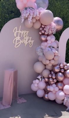 balloons and flowers decorate the entrance to a birthday party