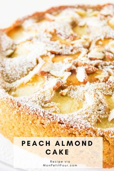 a cake with powdered sugar on top and the words peach almond cake above it