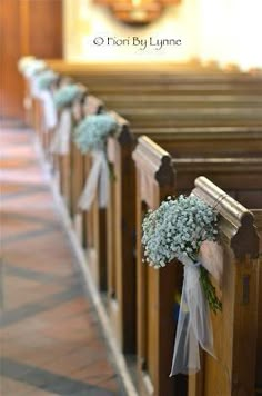 a row of pews with flowers tied to them