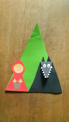 an origami wolf and girl standing next to each other on a wooden surface