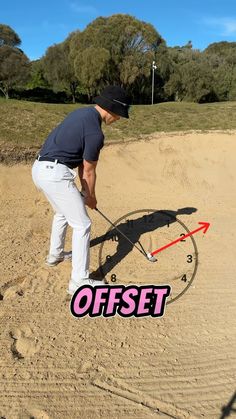 a man is bending over to put something in the sand with an arrow on it