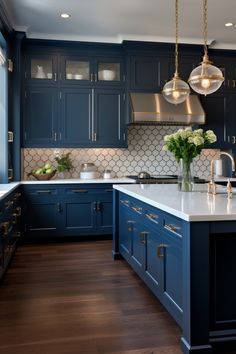 a large kitchen with blue cabinets and white counter tops, along with an island in the middle