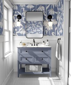 a bathroom with blue and white wallpaper, two sinks and a large mirror on the wall