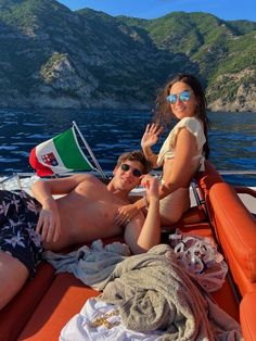 two people on a boat waving at the camera