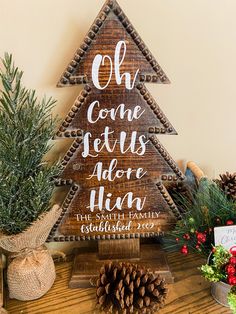 a christmas tree made out of wood with the words oh come jesus above it and pine cones