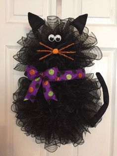 a black cat wreath hanging on the front door