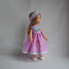 a doll wearing a pink dress and headband