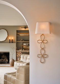 a living room filled with furniture and a fire place next to a wall mounted mirror