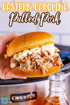 a pulled pork sandwich is being held up in front of an instant pot