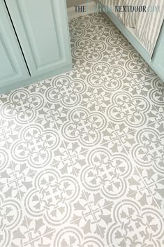 a bathroom floor with an ornate pattern on the tile in grey and white color scheme