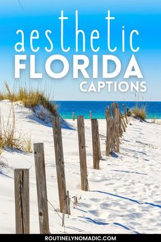 the beach is covered in white sand and there are wooden posts on each side that lead to the ocean