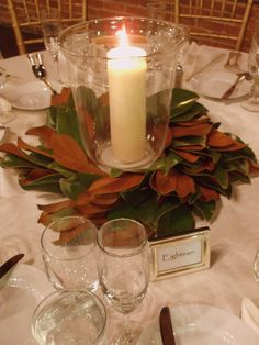 a candle that is sitting on top of a table with wine glasses and candlesticks