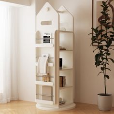 a white house shaped shelf next to a potted plant in a room with hardwood floors