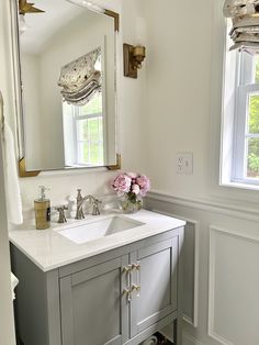 a bathroom with a sink, mirror and window in it's centerpieces