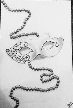 a drawing of a mask and beads on a piece of paper