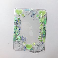 a glass frame with flowers and hearts on the bottom is attached to a white wall