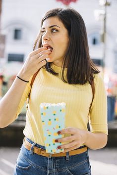 a woman is eating something out of a box