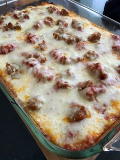 a casserole dish with meatballs and cheese on it sitting on a counter