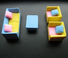 three pieces of furniture sitting on top of a black table with white and yellow accents