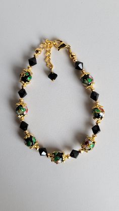 This bracelet is made of round black Cloisonné' beads, Swarovski Jet Black Crystal and gold plated beads and findings. It has a 1" extension with a beaded drop making it adjustable. It has a lobster claw clasp.  Cloisonné is the technique of creating designs on metal vessels (cloisons) with colored-glass paste placed within enclosures made of copper or bronze wires, which have been bent or hammered into the desired pattern.  Custom Orders are always welcome! Ask about free sizing. Making Jewelry For Beginners, Swarovski Crystal Jewelry, Providence Ri, Black Flower, Beads Bracelet, Black Crystals, Making Jewelry, Jet Black, Beading Patterns