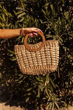 A summer essential, our pretty tan 'Barbados Bound' bag featuring woven raffia material, two circle wood tote handles, and a spacious interior! Wood Tote, Pretty Tan, Raffia Bag, Woven Raffia, Summer Essential, Barbados, Summer Essentials, Straw Bag, Handles