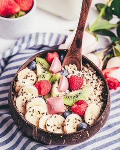 a bowl filled with sliced bananas, kiwis and strawberries on top of a striped table cloth