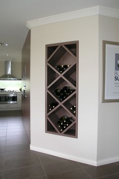 a wine rack in the corner of a room with tile flooring and white walls