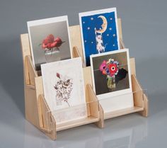 three cards in a wooden holder with flowers and pictures on the front one is holding a flower vase