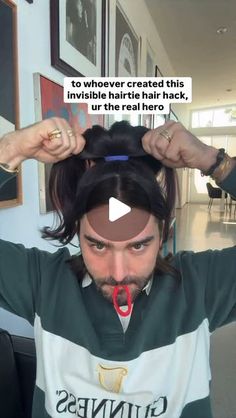 a man with long hair is holding his head in front of the camera and has an ad on it