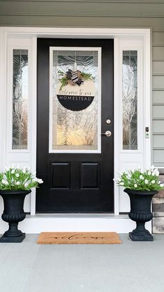 the front door is decorated with two large planters