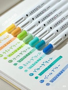 several markers are lined up on a sheet of paper