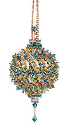 a beaded ornament hanging from a chain on a white background with blue and green beads