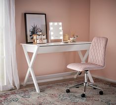 a white desk with a pink chair next to it and a framed photograph on the wall