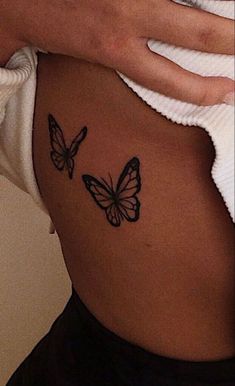 a woman's stomach with two butterflies on it and the bottom part of her belly