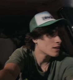 a woman wearing a green hat sitting in the back seat of a car