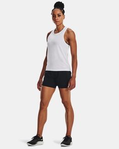 a man in black shorts and a white tank top is standing with his hands on his hips