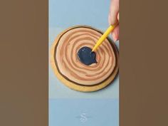 a person is using a marker to paint the inside of a cookie