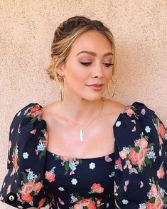 a woman wearing a black floral print dress