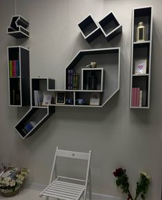 a white chair sitting in front of a book shelf